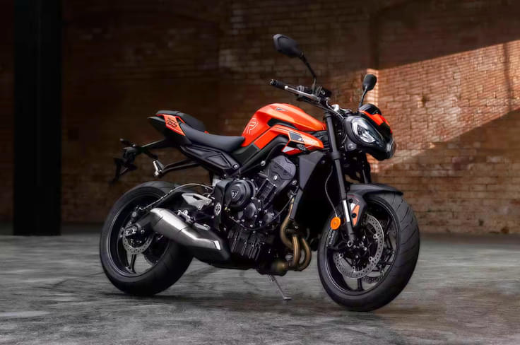 It’s powered by a 765cc, inline triple engine producing 120hp and 80Nm Triumph Street Triple R in orange front three quarter shot